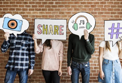 Friends holding up thought bubbles with social media concept icons